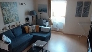 Een woonkamer met een hoekbank, een salontafel en een lamp.