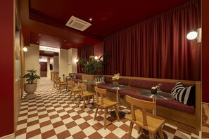 A restaurant interior with checkered flooring, wooden furniture, and red curtains. - TWENTYSEVEN Boutique (Budapest)