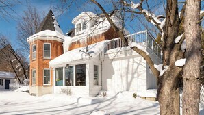 A two-story house with a snow-covered roof and a garage. - Muskoka Stay in Downtown Huntsville with Firepit (Huntsville)