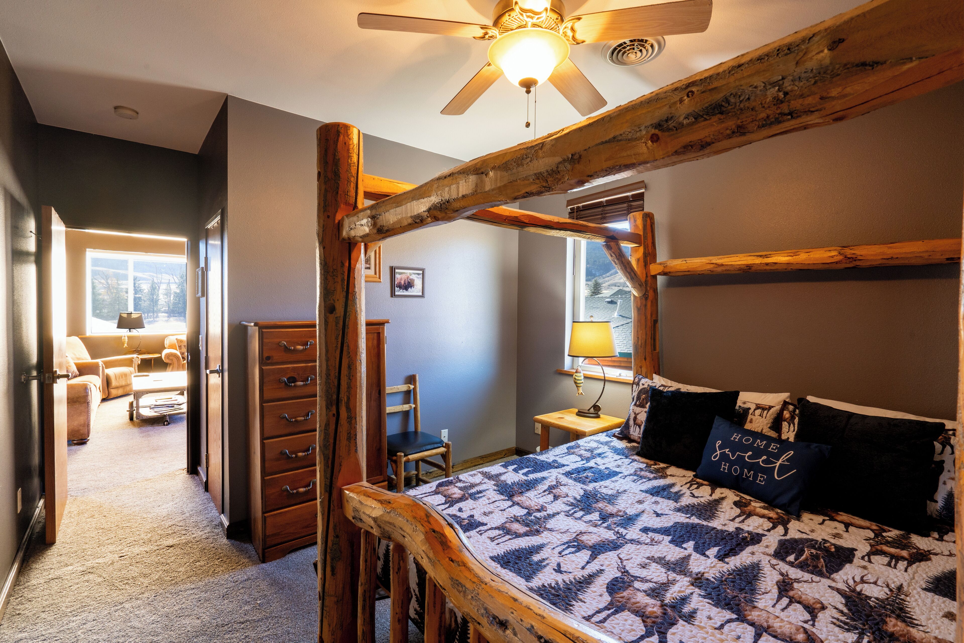 Una camera da letto con un letto a baldacchino in legno, una ventola a soffitto e una finestra vista all'esterno.