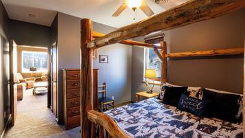 Una camera da letto con un letto a baldacchino in legno, una ventola a soffitto e una finestra vista all'esterno.