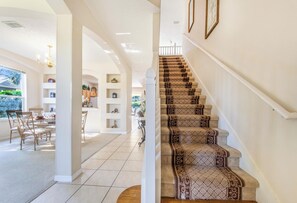 Ein geräumiger Wohnbereich mit einer Treppe, die zu einer oberen Etage führt.