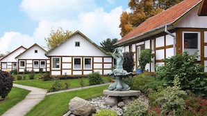 A traditional building with a garden, a statue, and a pathway. - Feriendorf an der Ostsee, Wohlenberg (Klütz)