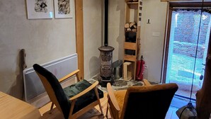 Un interior de madera con sofá, mesa, chimenea y ventana.