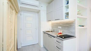A modern kitchen with white cabinetry, a built-in stove, and a countertop. - Sophie 1 - Old Town Heritage Suite (Dubrovnik)