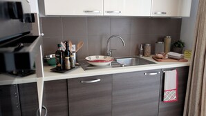 Ett modernt kök med en diskho i rostfritt stål, en mikrovågsugn och en inbyggd ugn.