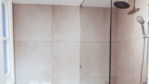 A bathroom with a toilet, sink, shower, and hexagonal patterned floor. - we saw athens from 4b (Athina)