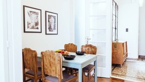A dining area with a light blue table, wooden chairs, and a fruit bowl. - we saw athens from 4b (Athina)