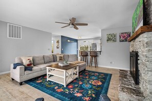 A living room with a sofa, coffee table, and a patterned rug.