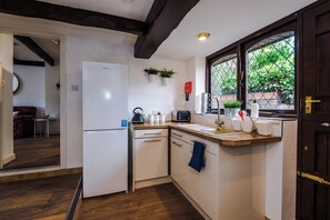 Une cuisine de taille réduite, avec un réfrigérateur blanc, un grille-pain et un évier.