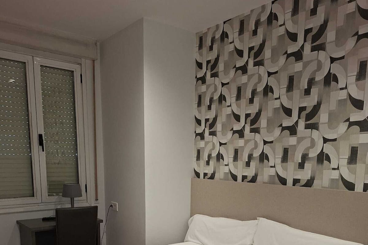 Une chambre à coucher avec un lit, un bureau et une chaise.