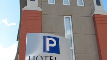 A hotel sign with a parking symbol and an arrow indicating direction.