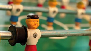 En närbild på ett fotbollsspel med spelpjäser.