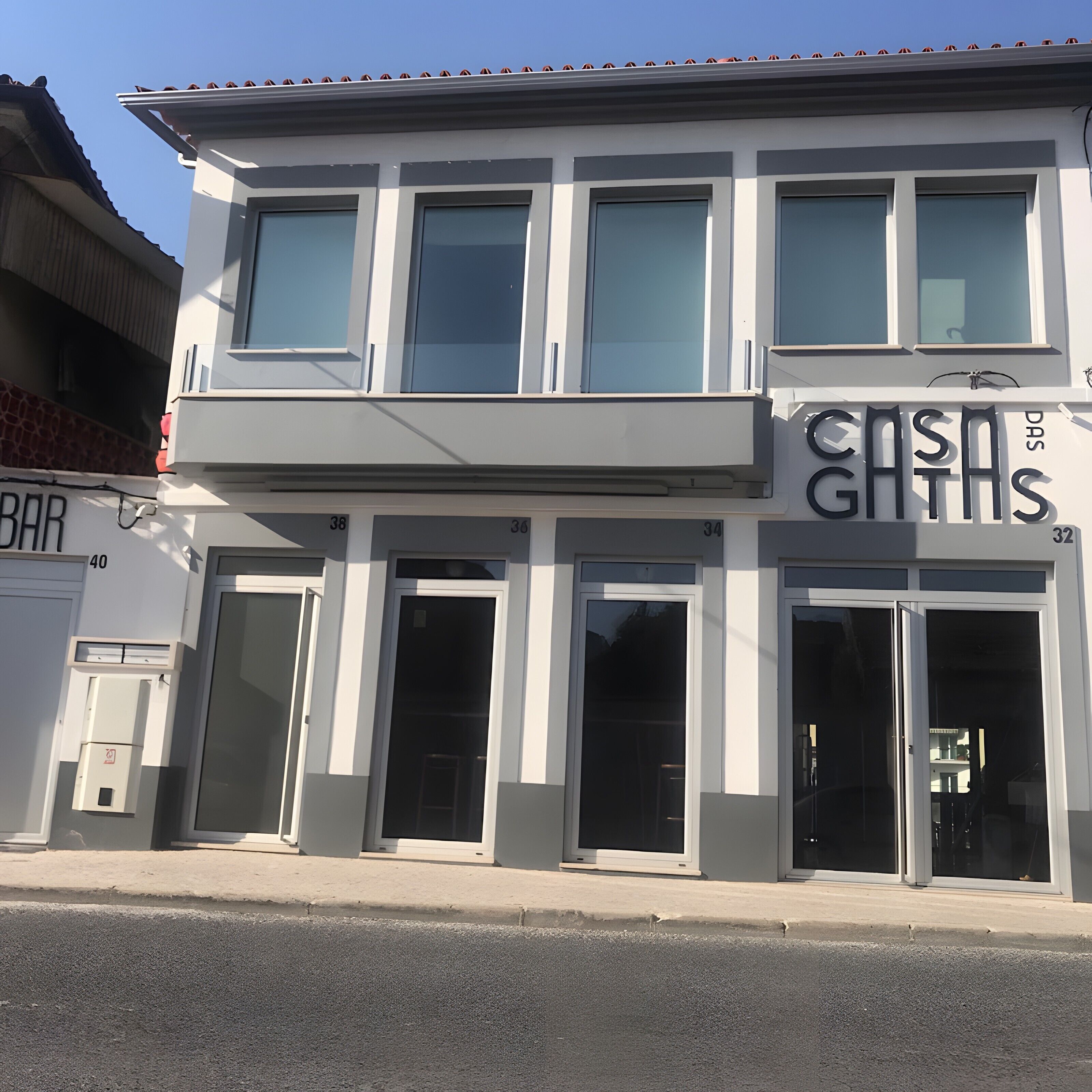 A two-story building with large windows and a storefront with signage.