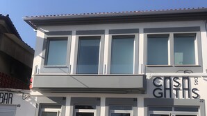 Un edificio de dos pisos con grandes ventanas y escaparate con señalización.