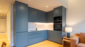 A modern kitchen with blue cabinets, a microwave, and an oven. - FLH Heart of Rossio Apartment X (Lisboa ciudad)