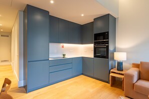 Eine moderne Küche mit blauen Schränken, einer Mikrowelle und einem Backofen.