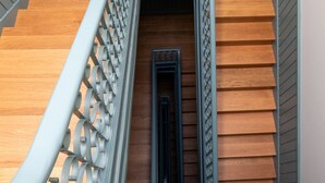 A wooden staircase with a metal railing and a small window at the top. - FLH Heart of Rossio Apartment X (Lisboa ciudad)