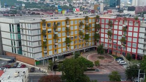 Un hôtel à plusieurs étages doté d’une cour intérieure, entouré d’immeubles modernes.