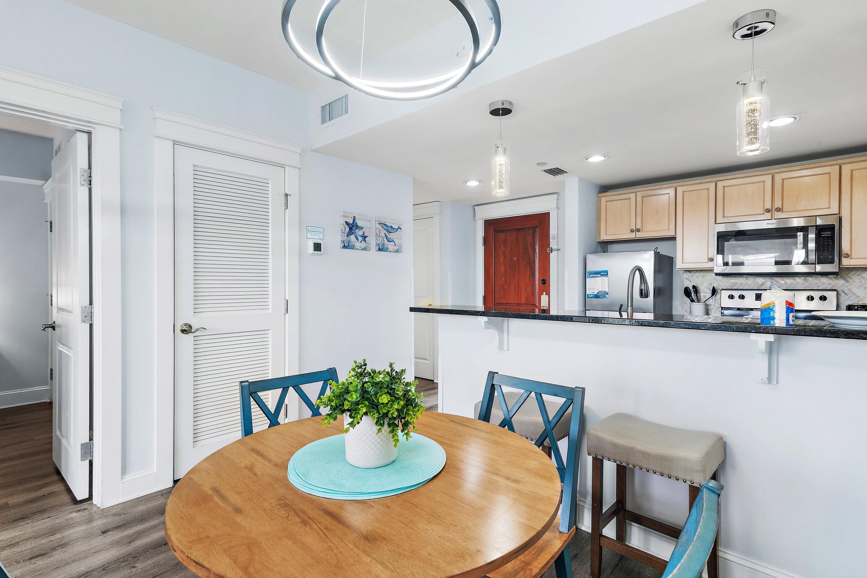 A modern kitchen with a microwave, refrigerator, and wooden cabinets.