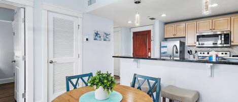 A modern kitchen with a microwave, refrigerator, and wooden cabinets.