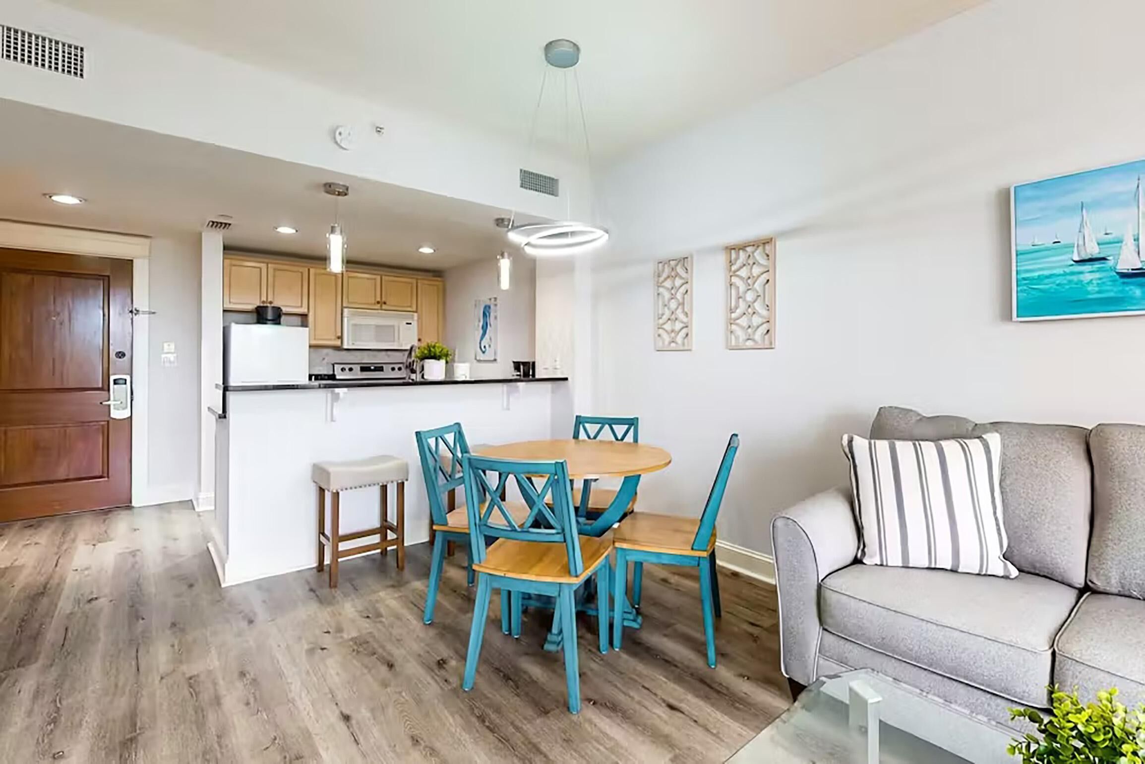 A modern kitchen with wooden cabinets, a central island, and pendant lighting.