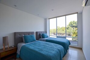 A bedroom with two beds, a nightstand, a lamp, and a large window with a view of trees and a parking lot. - Zona Médica, 4 camas, Agua 24/7 - #CentroMty (Monterrey)