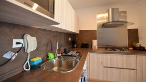 Uma cozinha moderna com telefone embutido, cafeteira e fogão a gás.
