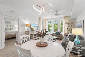 Una sala de estar moderna con comedor, ventilador de techo y televisor.