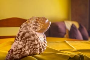 A shell on a yellow bedspread in a room with a wooden headboard. - 2-Bedroom Apartment with Pool and Garden View (5 Adults) (Luz)
