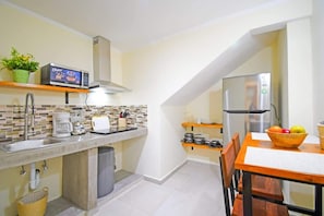 Eine kompakte Küche mit Mikrowelle, Toaster und Edelstahl-Kühlschrank.