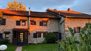 A stone building with a tiled roof, a brick pathway, and a grassy yard. - Guest Rooms “La Grande & La Jumelle” with Shared Terrace, Garden, and Wi-Fi (Soubrebost)