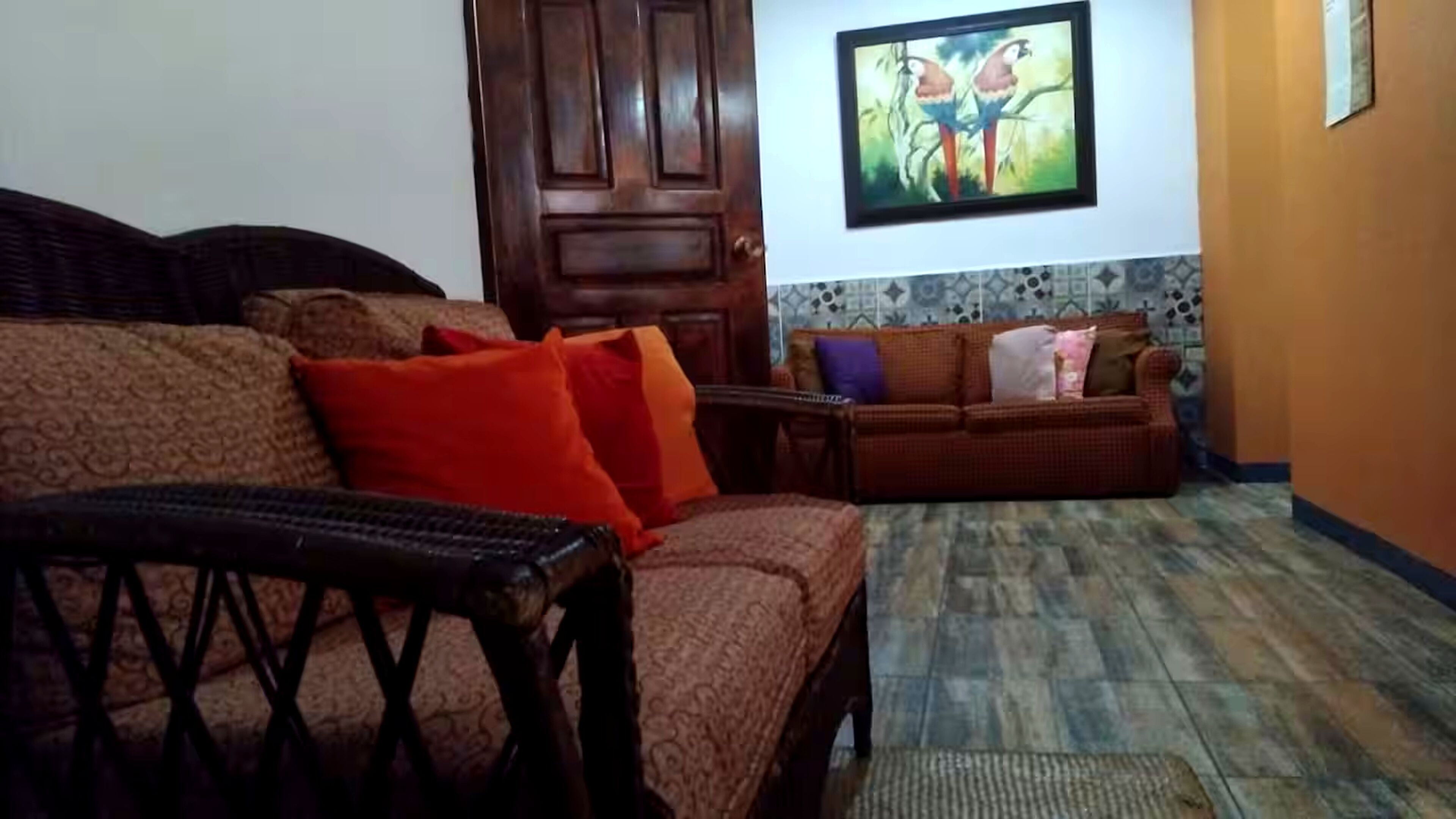 Ein Wohnzimmer mit einer Couch, einem Holztisch und einem gemusterten Teppich.