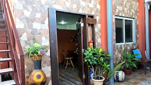 A stone facade with a wooden door, a window, and potted plants.