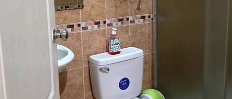 A bathroom with a toilet, bidet, and hand dryer.