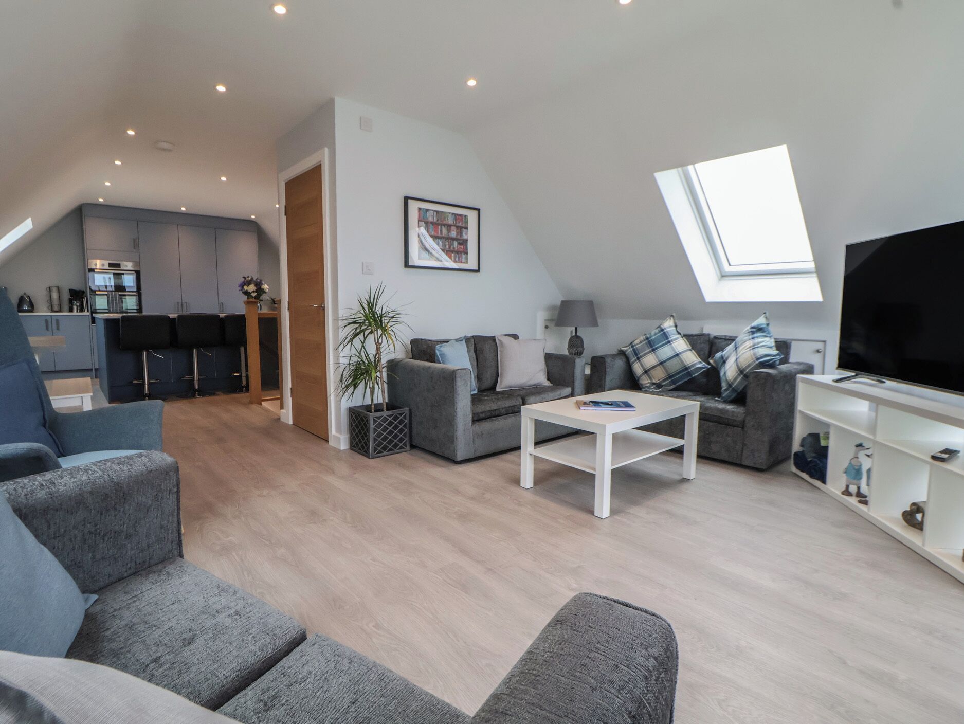 A modern living space with a loft bedroom, a kitchen, and a dining area.