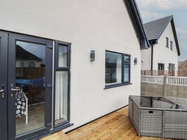 Una casa moderna con un patio, una puerta corrediza de vidrio y un pequeño espacio de estar al aire libre.