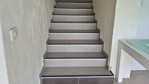 A staircase with a light-colored wall on one side and a white wall on the other, leading to a landing area. - T2 Vert Anis Apartment with Wi-Fi (Salies-de-Béarn)