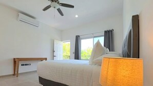 A bedroom with a bed, a ceiling fan, a window with curtains, and a door leading outside. - Shared Pool Oasis  Near Malecon  BBQ  Wi-Fi (La Paz)