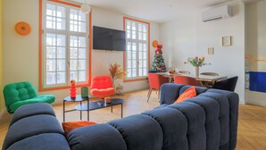 A living room with a large window, a flat-screen TV, and a Christmas tree.
