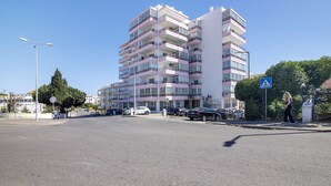 A multi-story residential building with balconies, a pedestrian crossing, and parked cars. - Holiday Apartment 'Panoramic View Apartment' with Sea View, Wi-Fi and Air Conditioning (Quarteira)