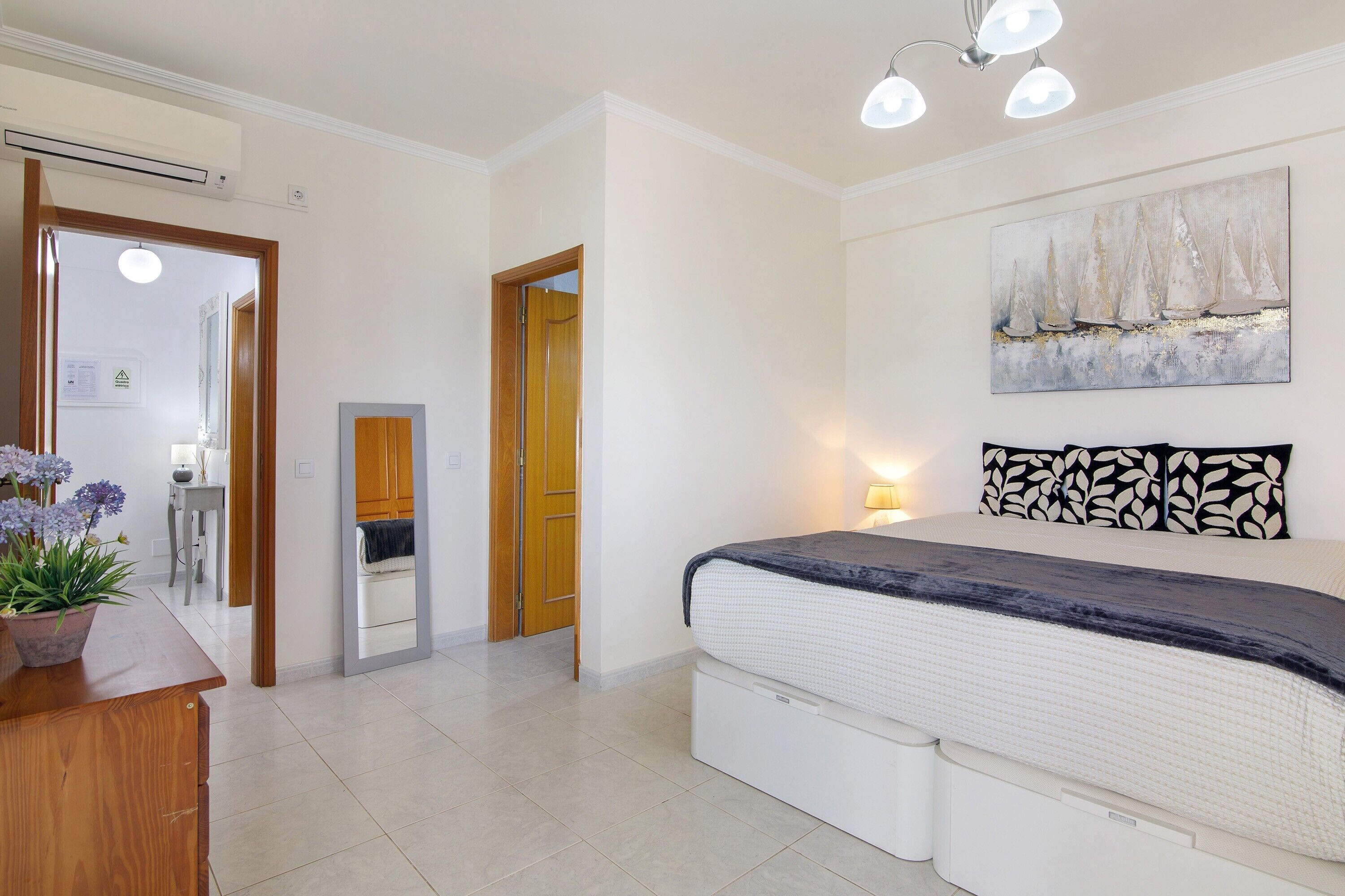Ein Schlafzimmer mit Bett, Nachttisch und einem Wandbild.