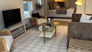 Ein modernes Wohnzimmer mit Flachbildfernseher, einer Couch, einem Couchtisch und einem Essbereich.