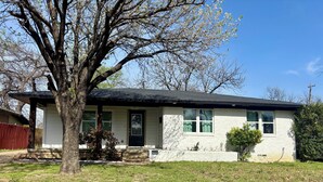 A single-story house with a front porch, a visible mailbox, and a tree in the front yard. - Up Up And Stayyyyy at this 3 bdrm Contemporary Home (Dallas)
