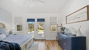 A bedroom with a bed, a dresser, a wall clock, and a framed quote.