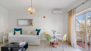 Une chambre moderne équipée d’un lit, d’une table à manger avec des chaises, d’une table basse et d’un balcon avec vue.