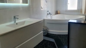 A bathroom with a white sink, a bathtub, and a toilet. - Apartment with TERRACE ON THE SEAwith breathtaking views. 50 meters from the beach (Gela)