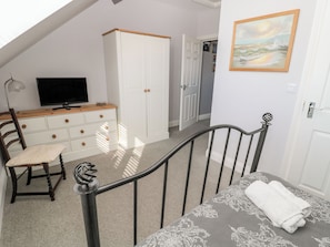A bedroom with a bed, a dresser, a television, and a painting. - Sunset Point (Alnwick)