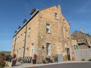 A two-story brick building with a flat roof, large windows, and a door. - Sunset Point (Alnwick)