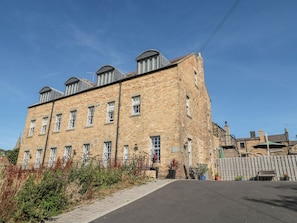 A multi-story brick building with a flat roof, several windows, and a paved entrance area. - Sunset Point (Alnwick)